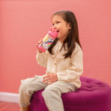 Little girl with rainbow flip top bottle