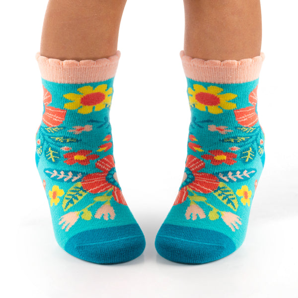 Child wearing turquoise floral toddler socks