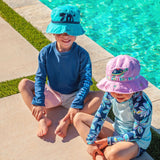 Little boy wearing sea monster bucket hat and girl wearing turtle bucket hat.