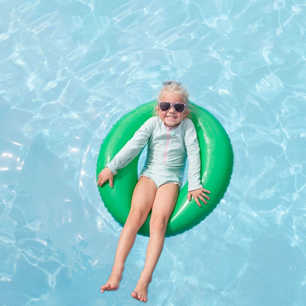 Little girl in the pool wearing sunglasses