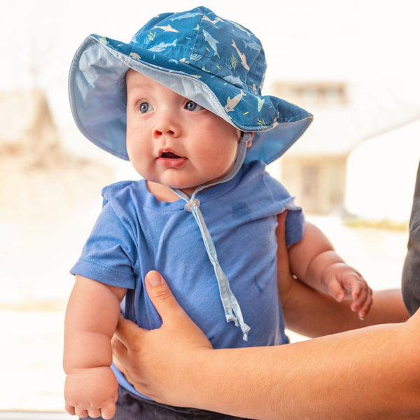 Baby wearing shark baby bucket hat.