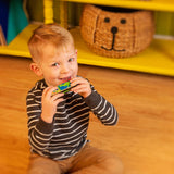 Little boy playing with green dino harmonica