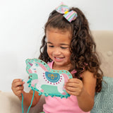 Little girl playing with unicorn lacing card set.