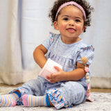 Baby wearing the striped socks from the unicorn set.