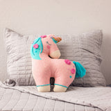 Unicorn embroidered pillow on a bed
