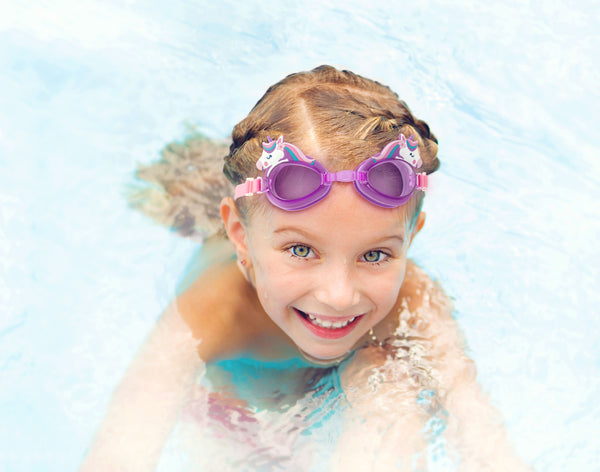 Little girl wearing unicorn swim goggles