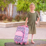 Little girl with charcoal flower rolling luggage