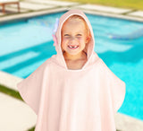Little girl wearing the mermaid beach poncho at the pool. 