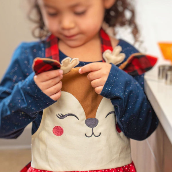 Little girl wearing girl reindeer holiday apron