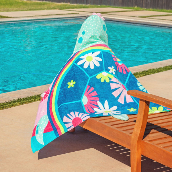 Child wearing turtle hooded towel by the pool