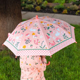 Child holding strawberry field umbrella