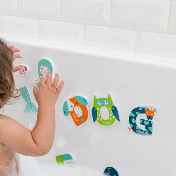 Child playing with blue foam bath toy letters. 