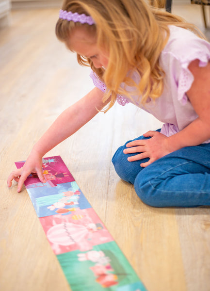 Little girl playing with girl story book puzzle