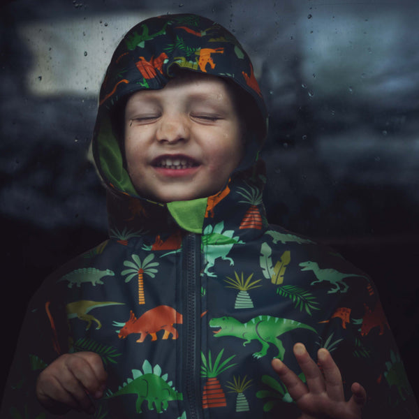 Little boy wearing Multi Dino boys rain coat.